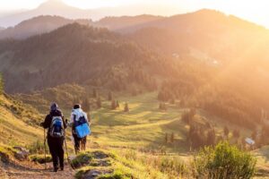 ストックを持って稜線の登山道を歩く2人の登山者
