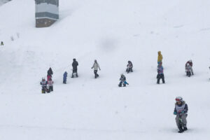 小出スキー場の雪面で子どもたちが雪遊びをしている様子