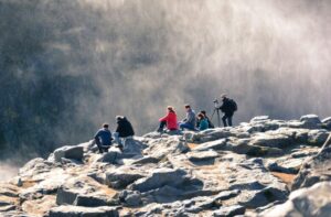 岩場に座布団を敷いて休憩する登山者のイメージ