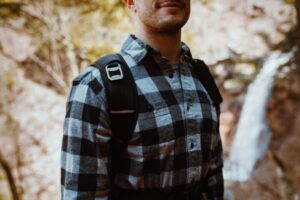 襟付きの長袖シャツを着て登山道を歩く人
